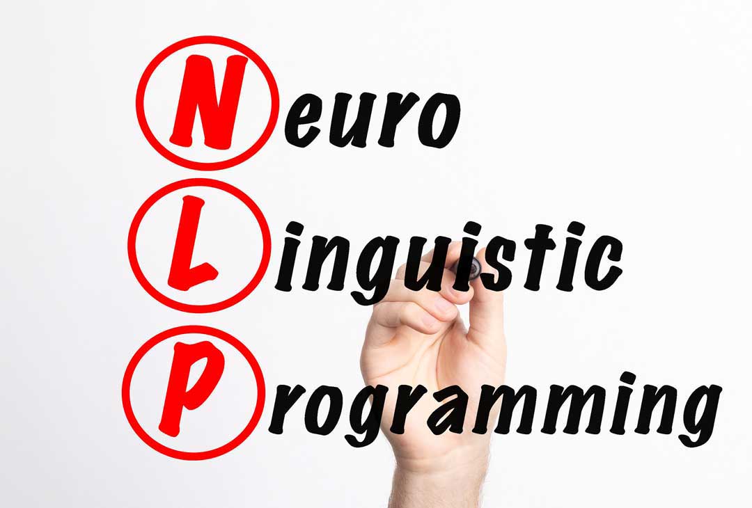 A person is writing the phrase Neuro-Linguistic Programming (NLP) on the screen